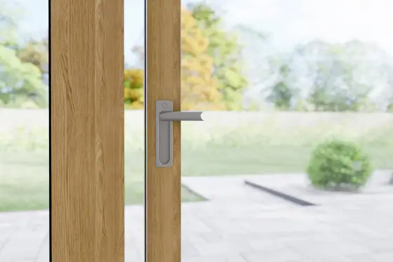 IGLO SLIDE dörrhandtag i silver på PVC-skjutdörr med träram – detaljvy från insidan